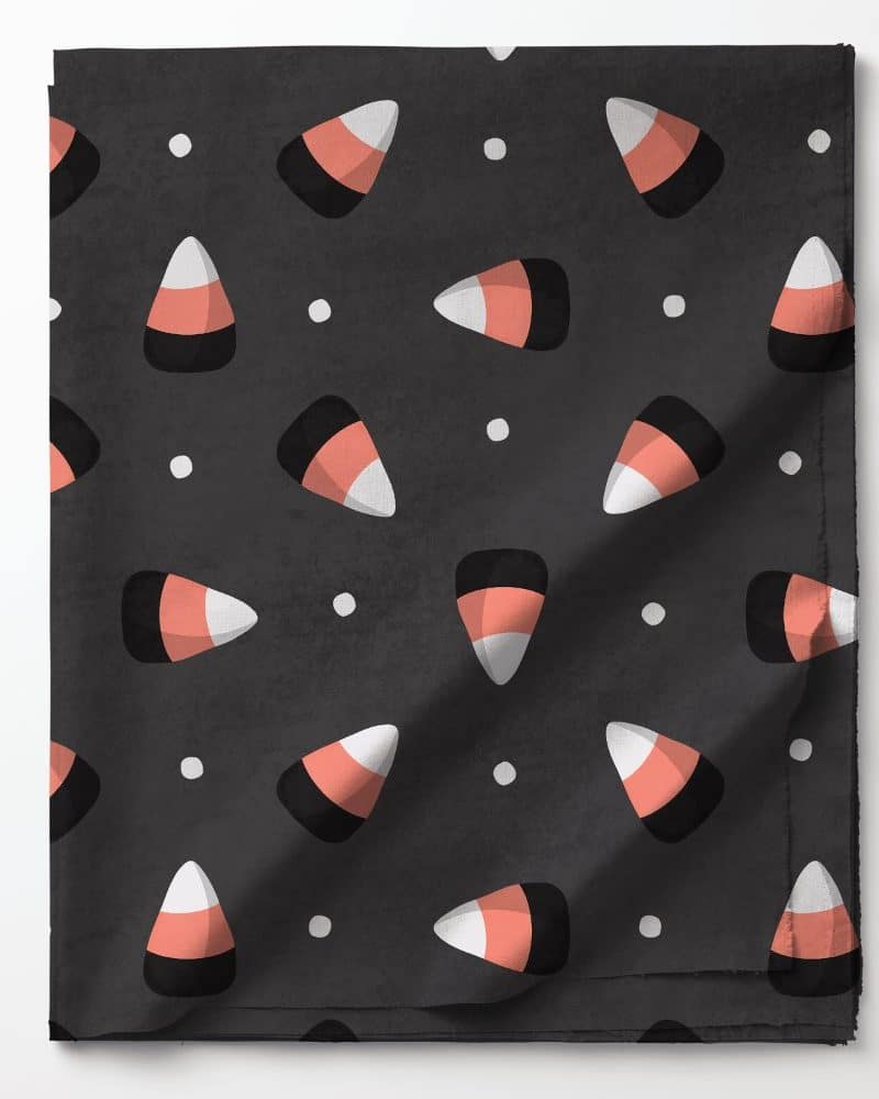 Dark gray fabric with a repeating pattern of candy corn.