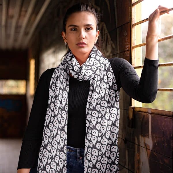 Woman Wearing A Black Long-Sleeved Shirt And A Black And White Ghost Patterned Scarf.