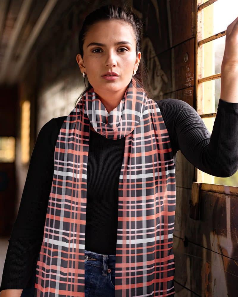 Woman wearing a coral and black plaid scarf.