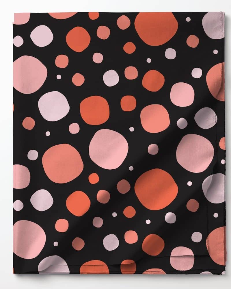 Black fabric with a pattern of pink and orange circles of varying sizes.