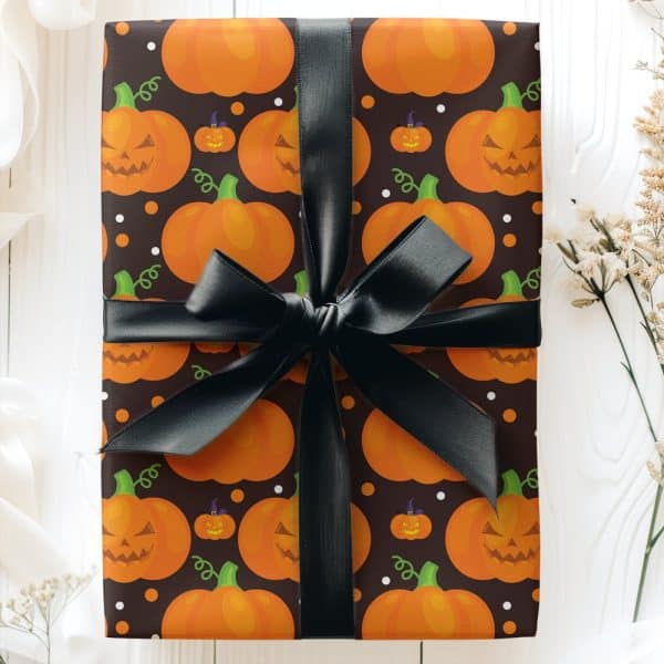 Halloween Gift Wrapped In Dark Brown Paper With A Pattern Of Orange Jack-O'-Lantern Pumpkins And A Black Ribbon.