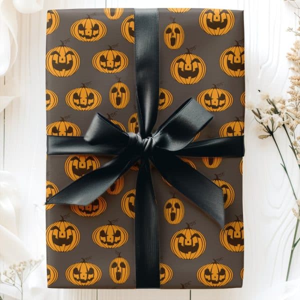 Halloween Gift Wrapped In Dark Gray Paper With A Repeating Pattern Of Orange Jack-O'-Lanterns And Tied With A Black Ribbon.