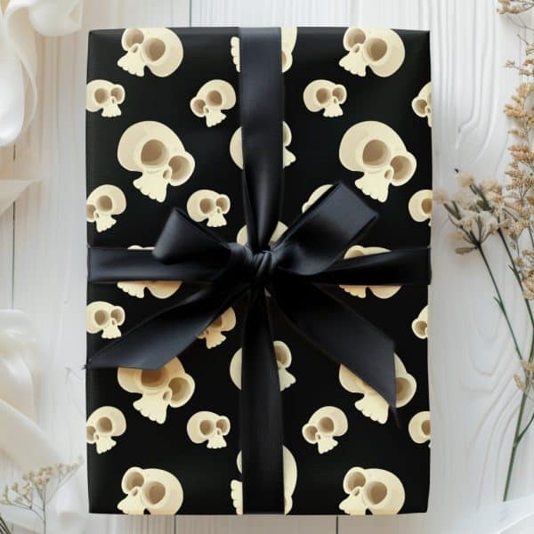 Gift Wrapped In Black Paper With A Repeating Pattern Of Cartoon Skulls And Tied With A Black Ribbon.