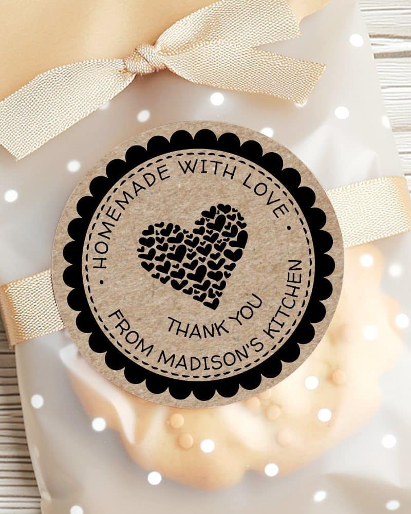 A round, kraft-colored sticker with a black border and text that reads Homemade with Love, Thank You from Madisons Kitchen. A large heart made of smaller hearts is in the center.