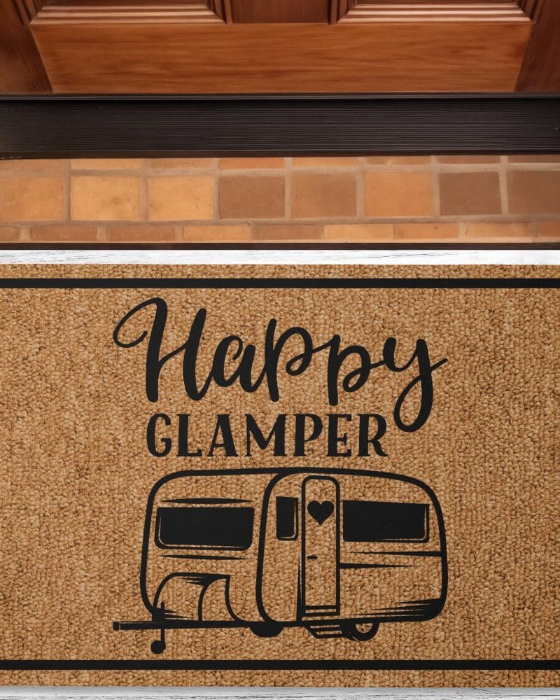 Tan doormat with black text and image of a camper. The text reads Happy Glamper.
