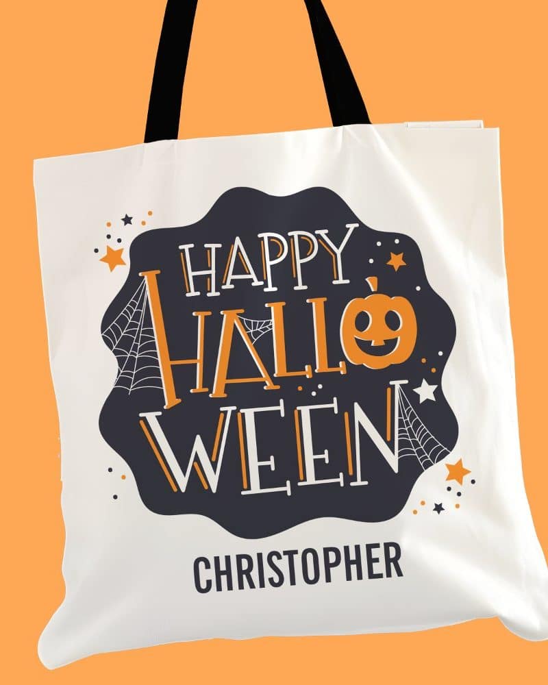 White tote bag with black and orange Halloween design, including the name Christopher.