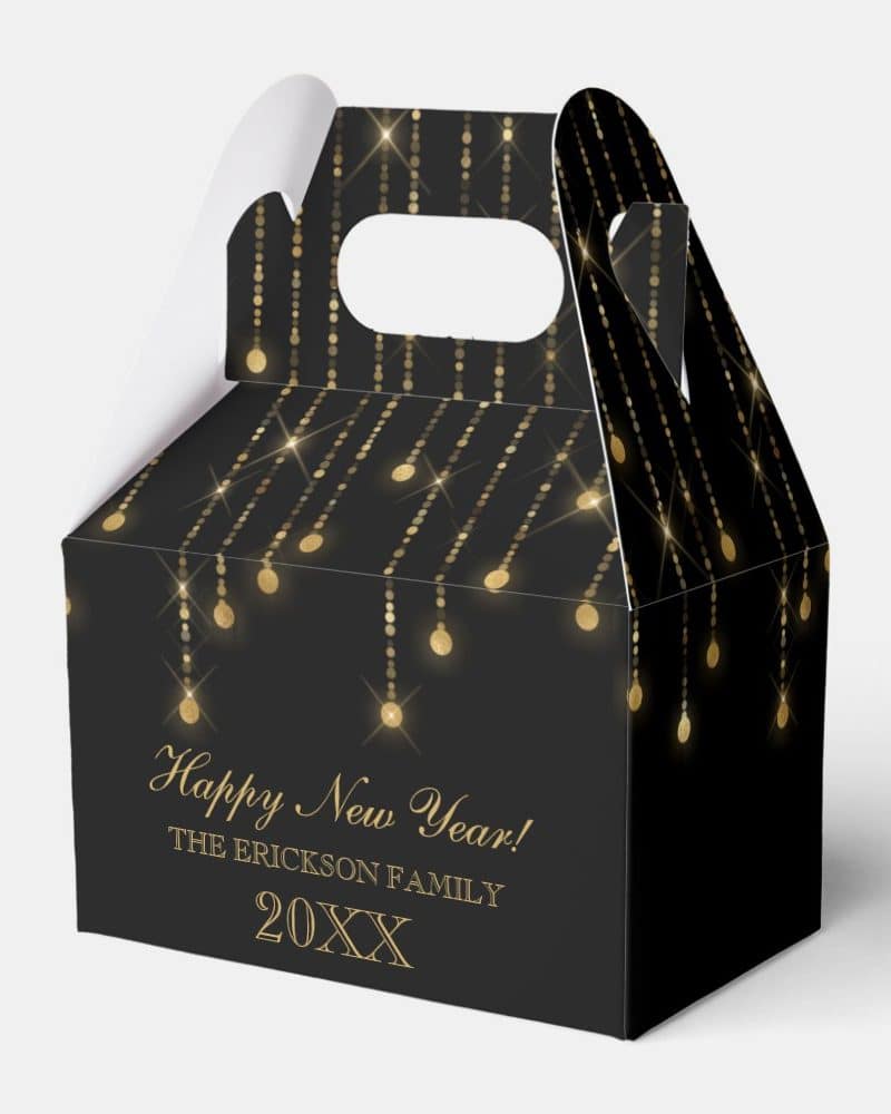 Black and gold New Year's treat box with a handle. The box features a pattern of gold string lights.