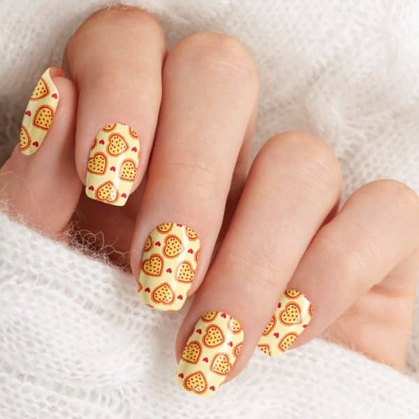 Close-Up Of Fingernails With Pizza-Shaped Heart Nail Art.