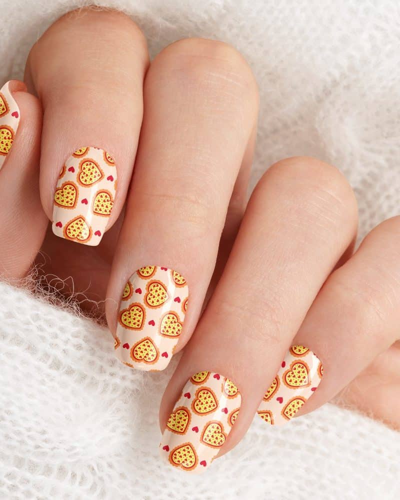 Close-up of fingernails with heart-shaped pizza nail art.