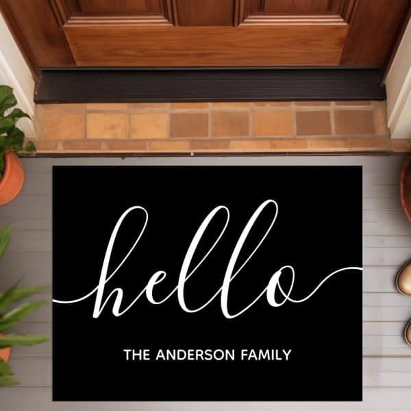Black Welcome Mat With White Script Lettering That Says Hello And The Anderson Family Below.