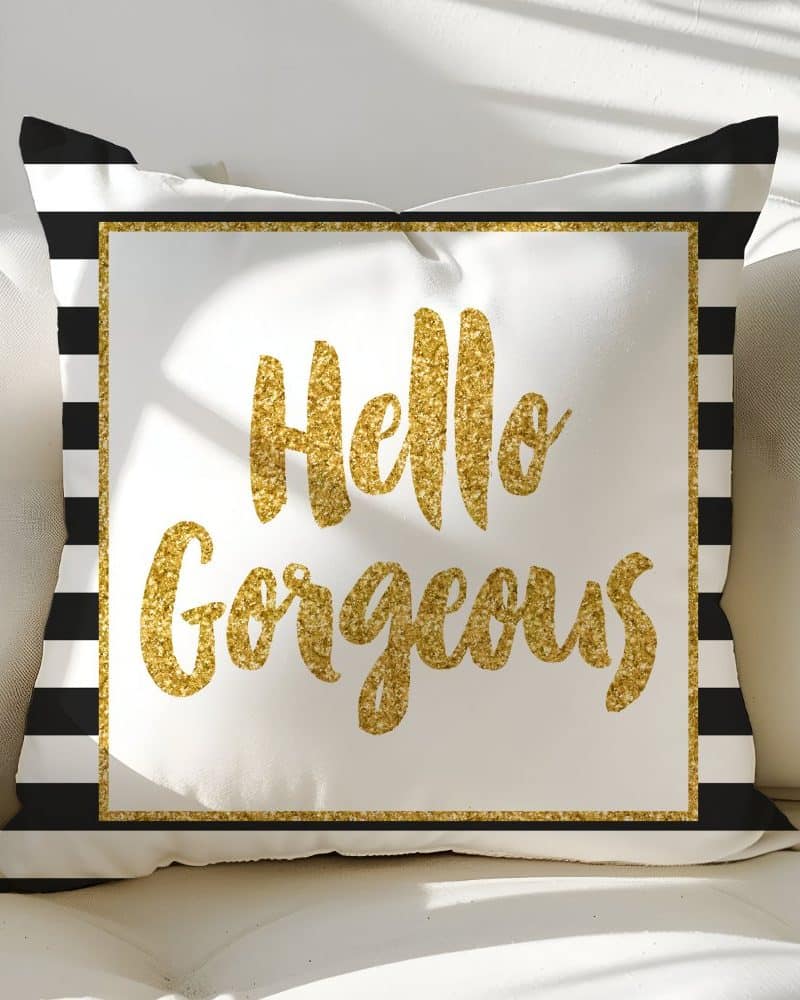White pillow with black stripes and gold glitter lettering that says Hello Gorgeous.