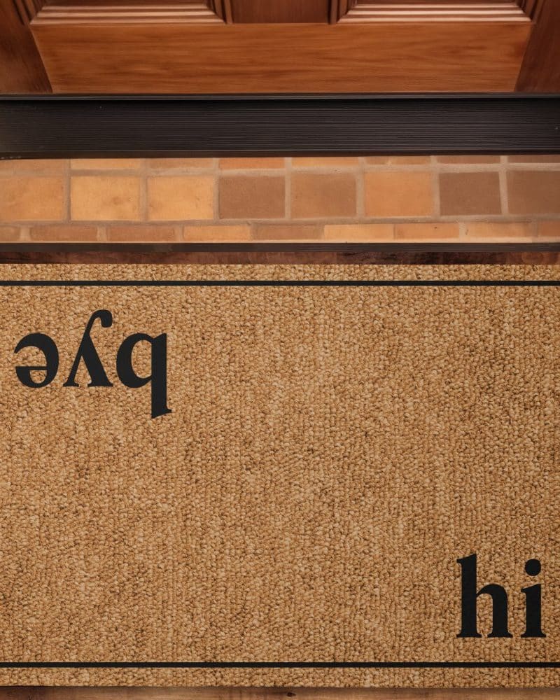 Tan coir doormat with black text that says "hi" and a backwards "pqe".
