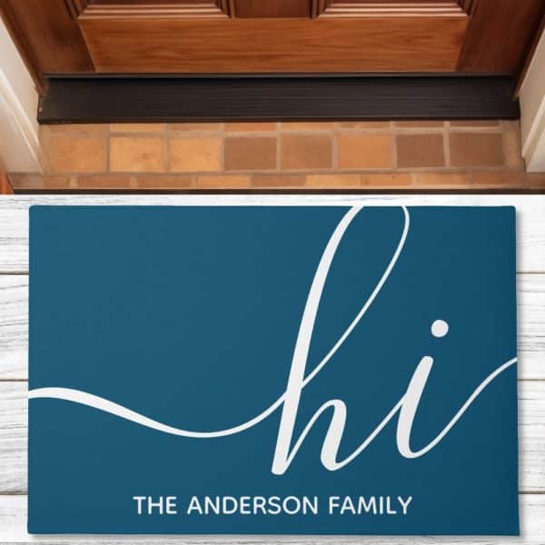 Teal Doormat With The Word Hi In A Stylized White Script Font And The Anderson Family Below.
