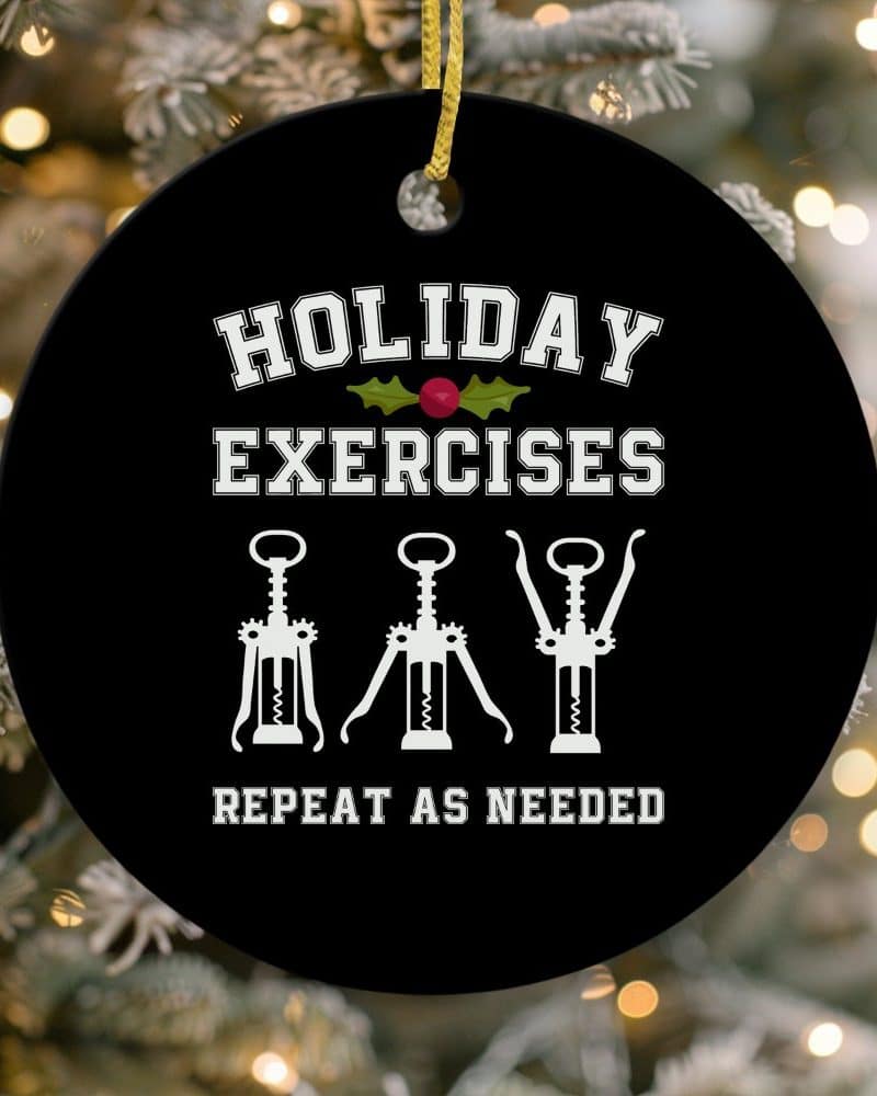 Round black Christmas ornament with white text that reads Holiday Exercises and shows three corkscrews; Repeat as needed is printed below.