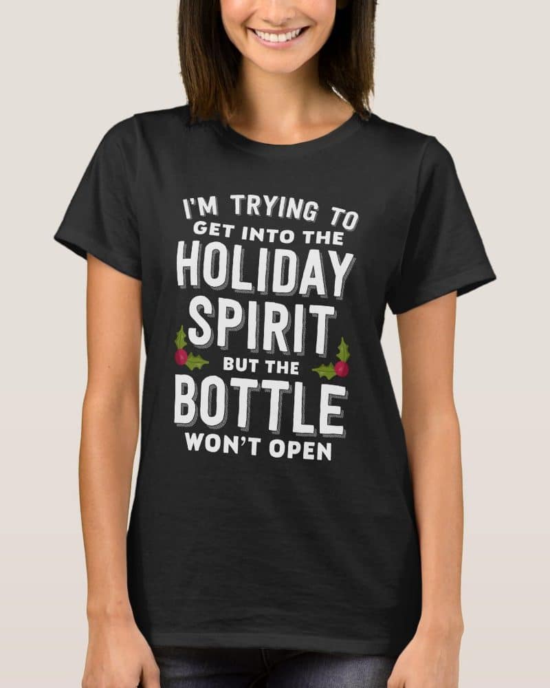 Woman wearing a black t-shirt with a humorous Christmas-themed message about holiday spirits.