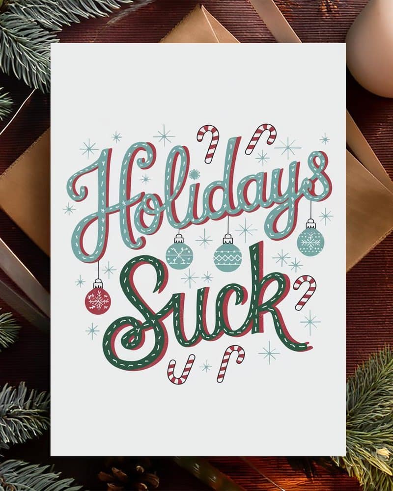 Humorous holiday card with the text Holidays Suck in decorative lettering, surrounded by ornaments and candy canes.