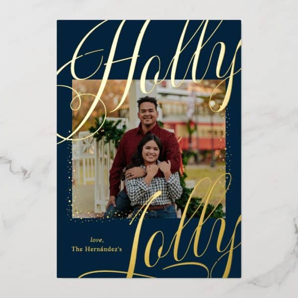 A Navy Blue Christmas Card Features A Photo Of A Couple Embracing, Surrounded By Gold Glitter. Gold Script Lettering Spells Out Holly Jolly.