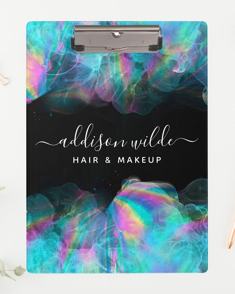 A clipboard with a black background and iridescent teal and pink abstract design. The name Addison Wilde Hair & Makeup is displayed in a white script font.