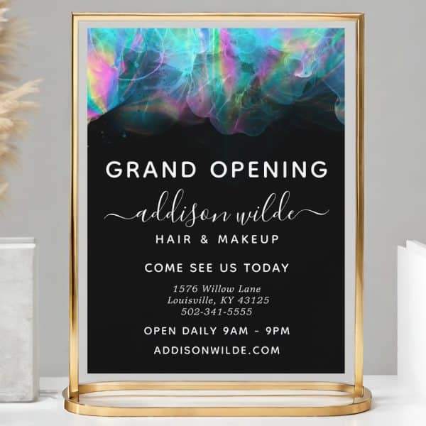 Gold-Framed Sign Announcing The Grand Opening Of Addison Wilde Hair &Amp; Makeup, Featuring A Colorful Abstract Design.