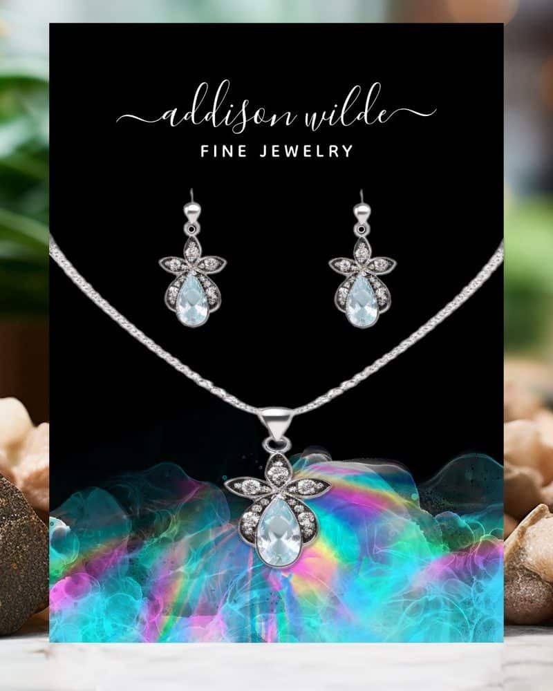 Aquamarine teardrop necklace and earring set with silver flower accents.