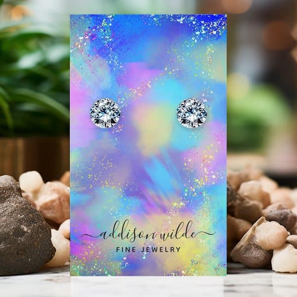 Pair Of Round Clear Stud Earrings Displayed On A Colorful Card.