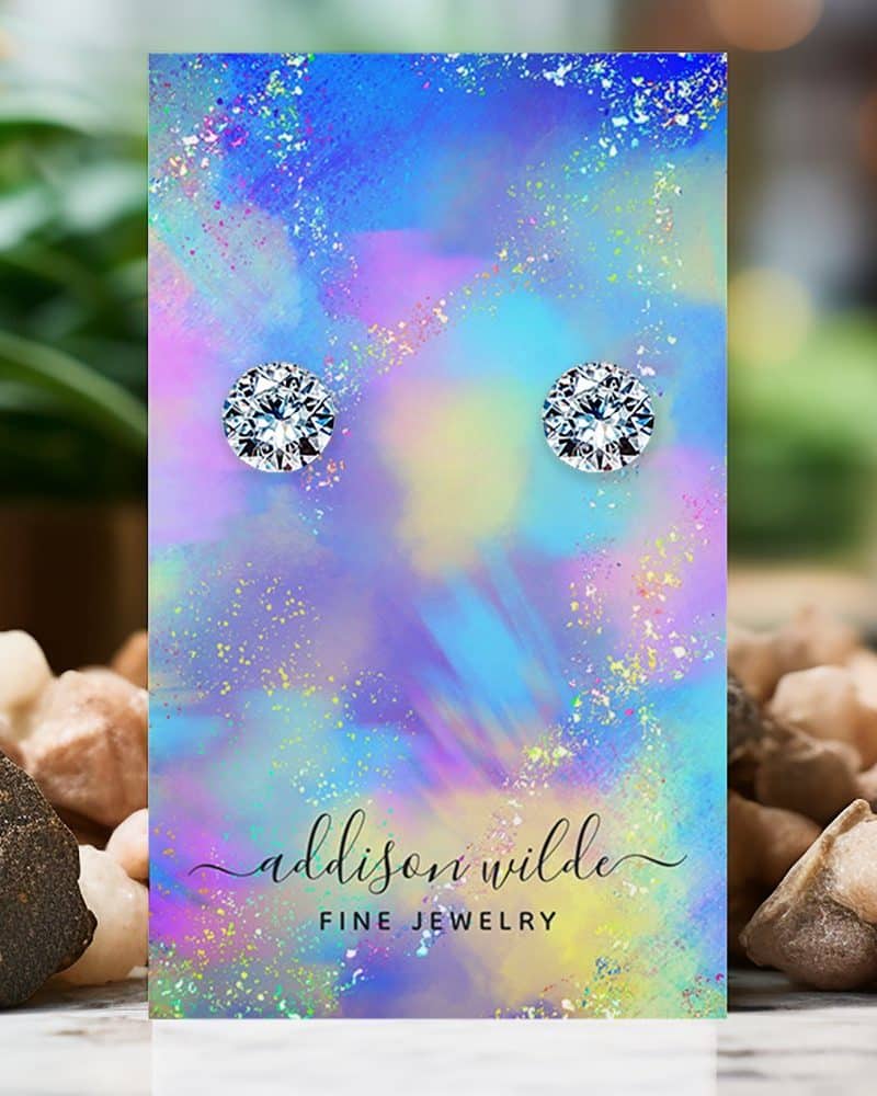 Pair of round clear stud earrings displayed on a colorful card.