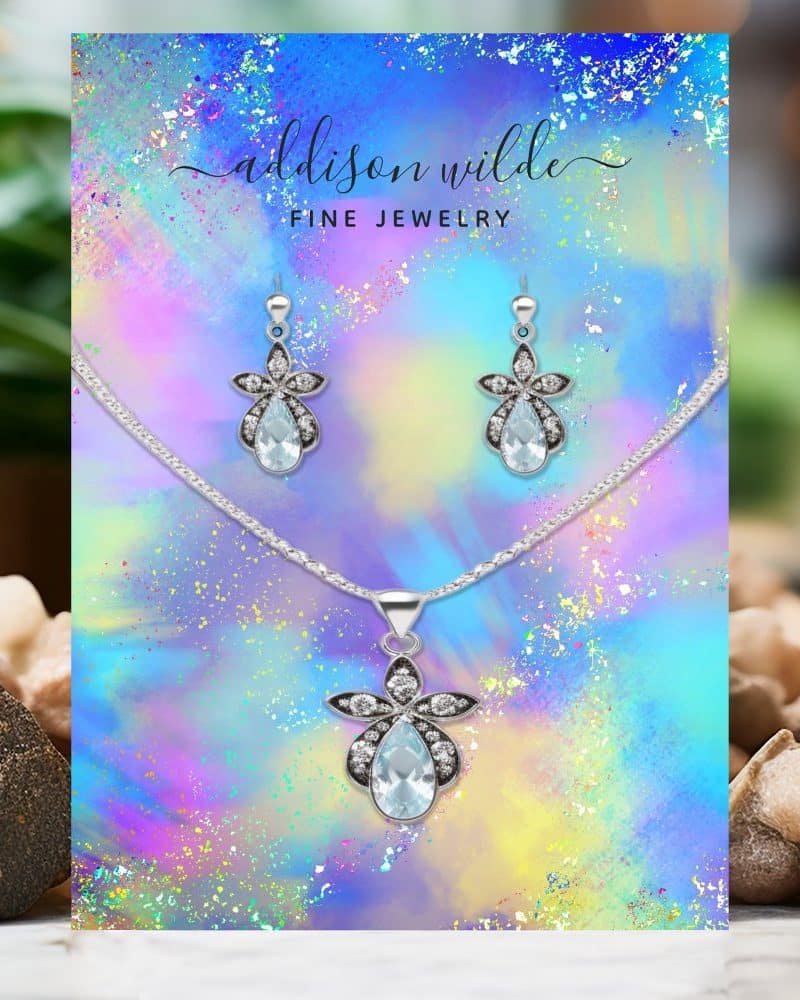 Silver necklace and earrings set with light blue teardrop gemstones.