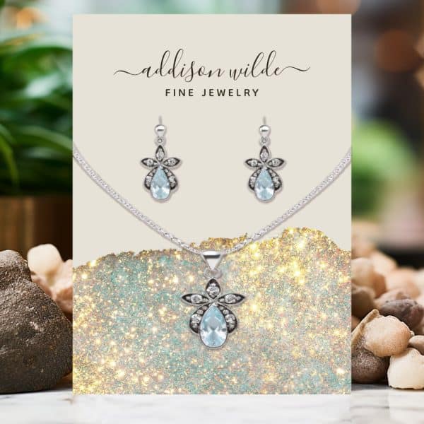Addison Wilde Fine Jewelry Set: A Necklace And Earrings Featuring Light Blue Pear-Shaped Gemstones With Silver Flower Accents.