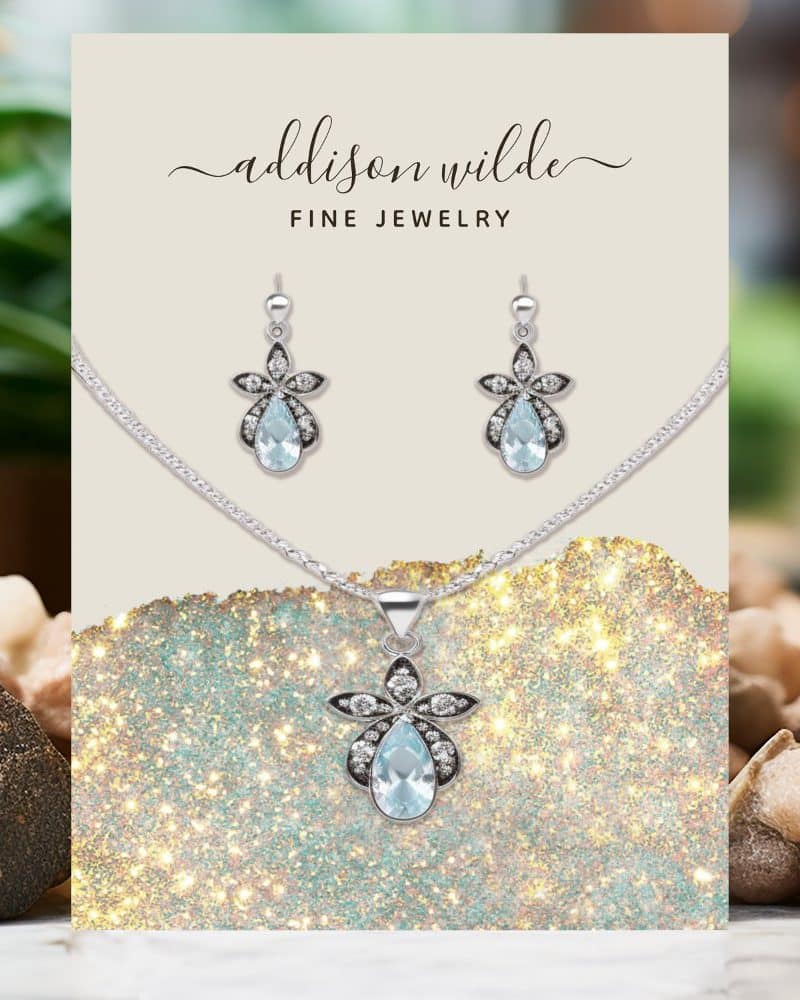 Addison Wilde fine jewelry set: A necklace and earrings featuring light blue pear-shaped gemstones with silver flower accents.