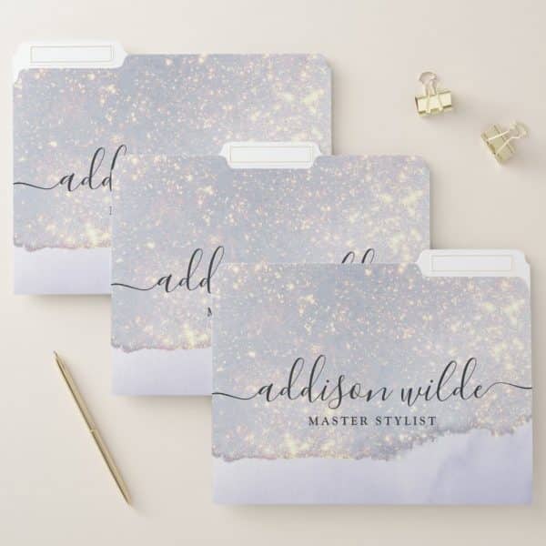 Three File Folders With A Sparkly Lavender Design. The Bottom Folder Is Labeled Addison Wilde, Master Stylist.