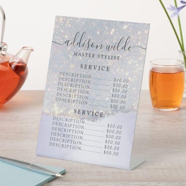 A Freestanding Price List For Addison Wilde, Master Stylist, Shows Services And Prices On A Sparkly Light-Blue Background.