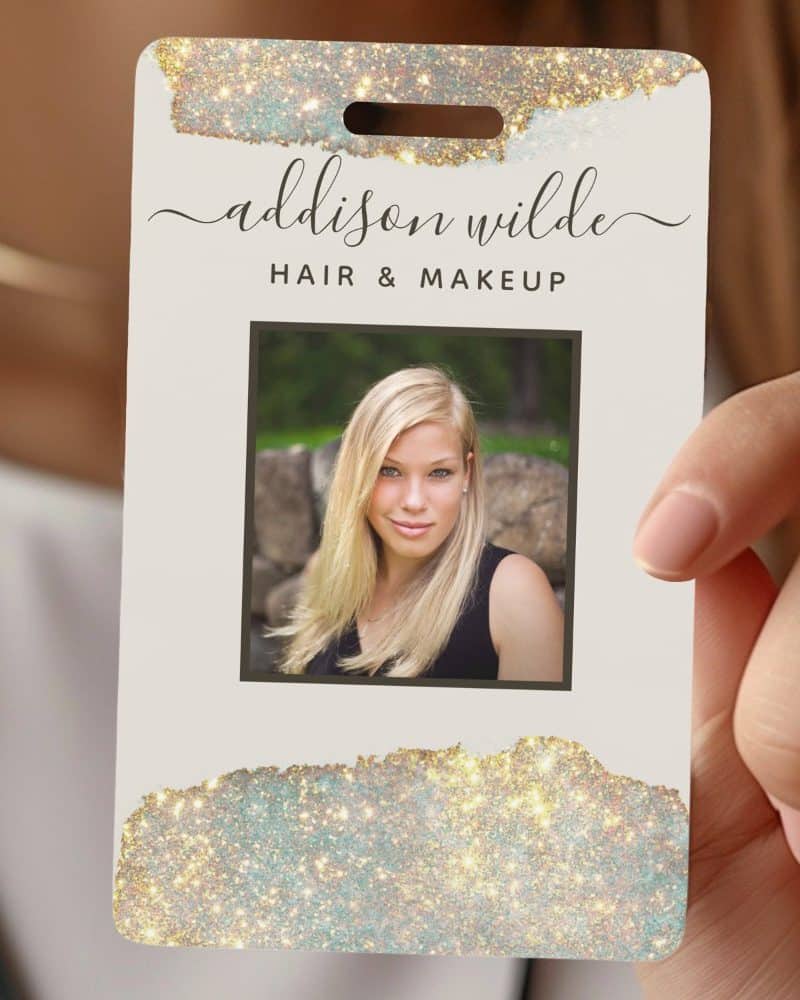 A business card for Addison Wilde Hair & Makeup featuring a photo of the owner. The card has a sparkly gold and teal design.