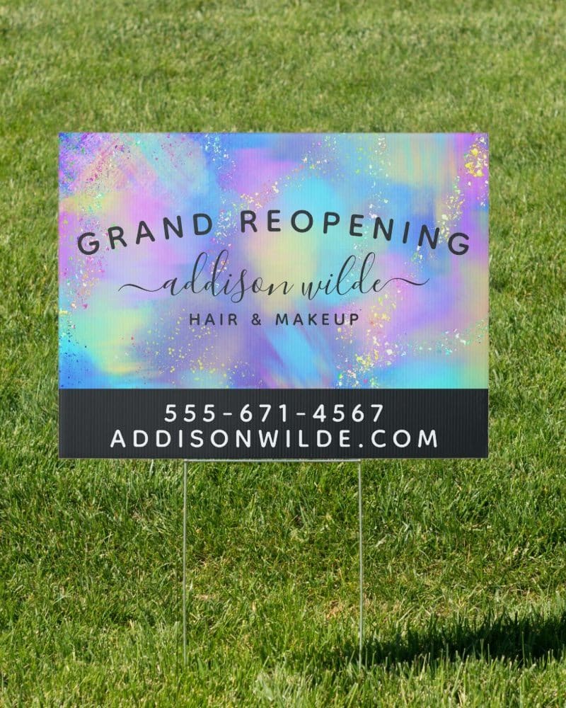 Grand reopening sign for Addison Wilde Hair & Makeup, featuring a colorful, iridescent background. Contact information is included.