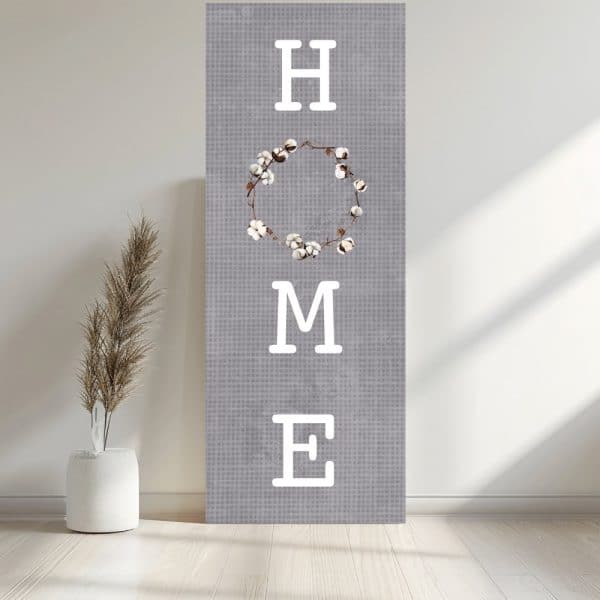 Gray Canvas With The Word Home In White Sans-Serif Font; A Cotton Wreath Replaces The Letter O.