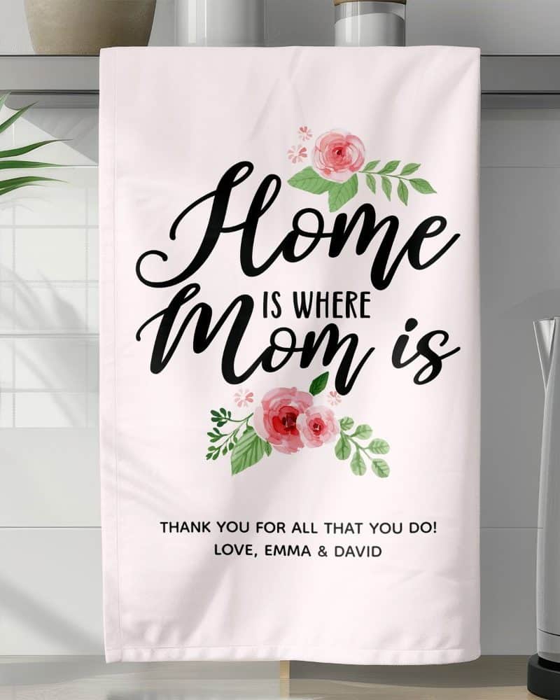 Pink tea towel with the text Home is where Mom is, surrounded by pink flowers.