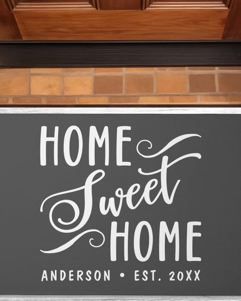 Dark gray welcome mat with white script lettering that says Home Sweet Home and the Anderson family name and establishment year.
