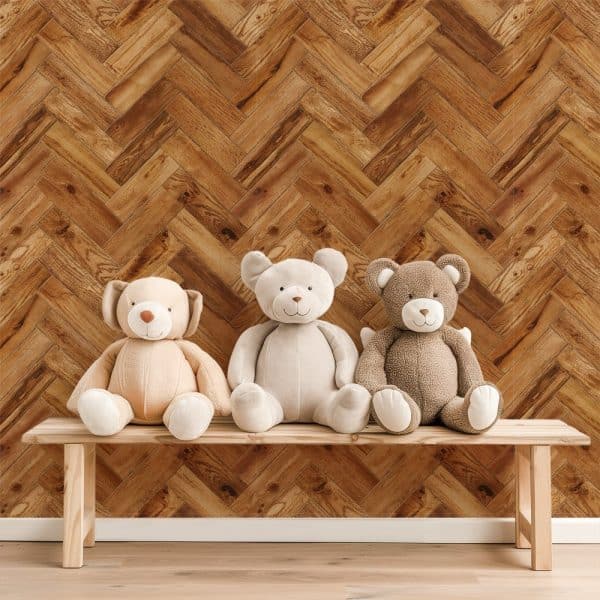 Three Teddy Bears Sitting On A Wooden Bench In Front Of A Herringbone Wood Pattern Wall.