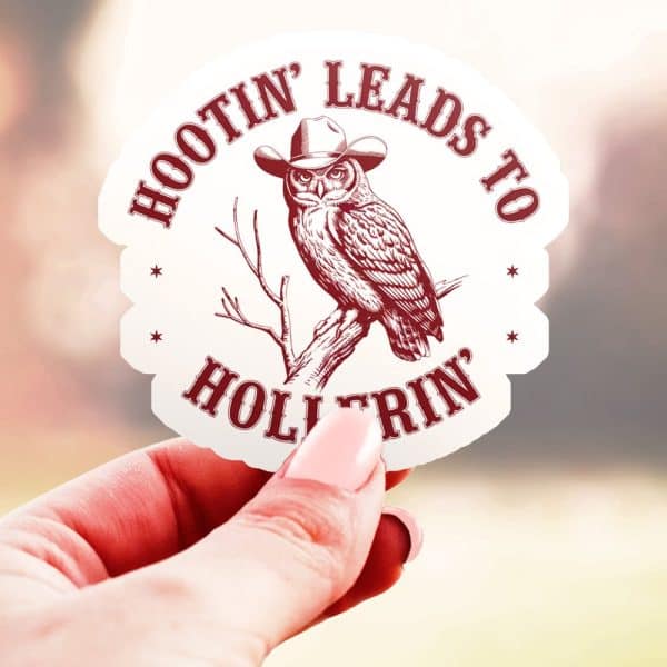 A Hand Holds A Sticker Featuring A Cowboy Hat-Wearing Owl Perched On A Branch. The Text Reads Hootin Leads To Hollerin.
