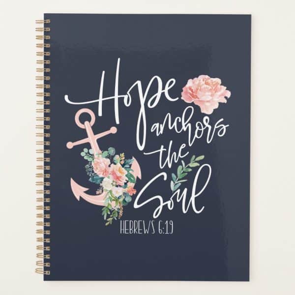 Spiral-Bound Notebook With A Navy Cover Featuring A Pink Anchor Adorned With Flowers, The Text Hope Anchors The Soul, And The Bible Verse Hebrews 6:19.