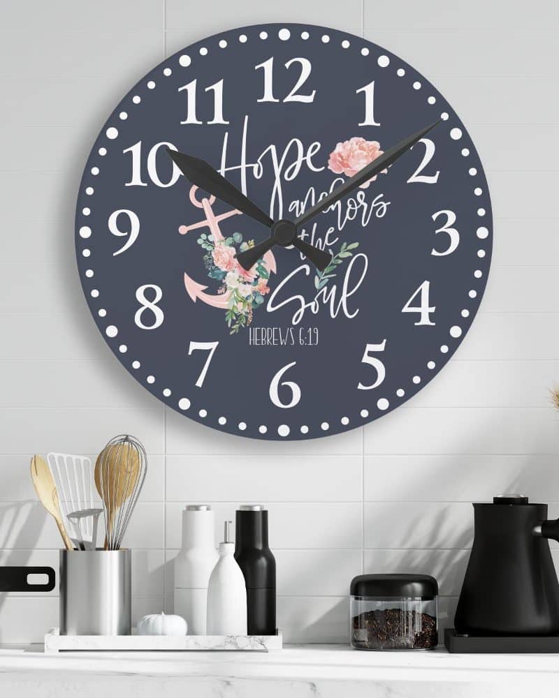Dark gray round wall clock with white numbers, an anchor, pink flowers, and the text Hope anchors the soul, Hebrews 6:19.