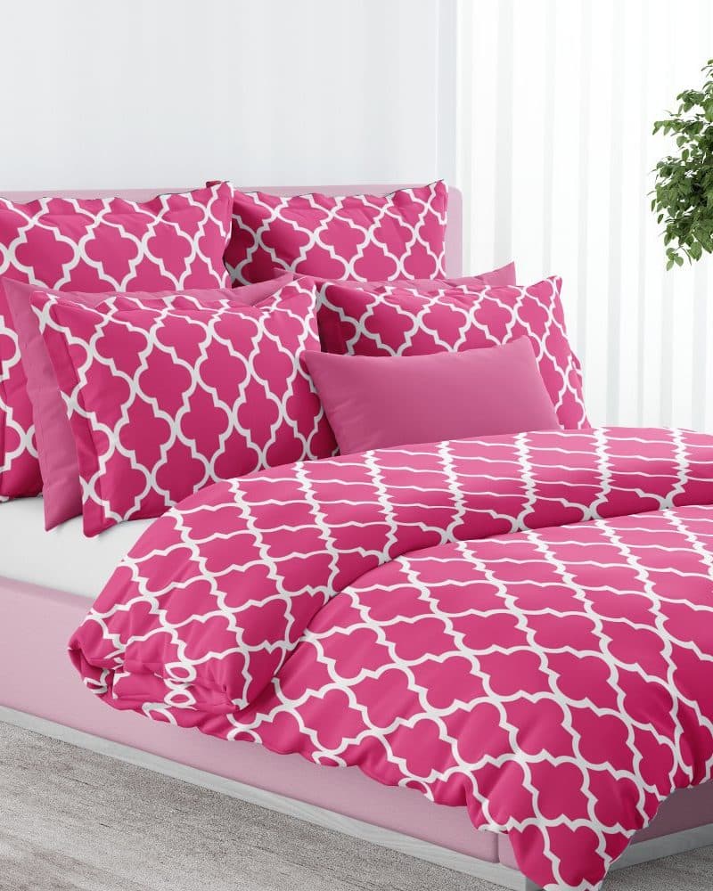 Pink bedding with a white quatrefoil pattern.