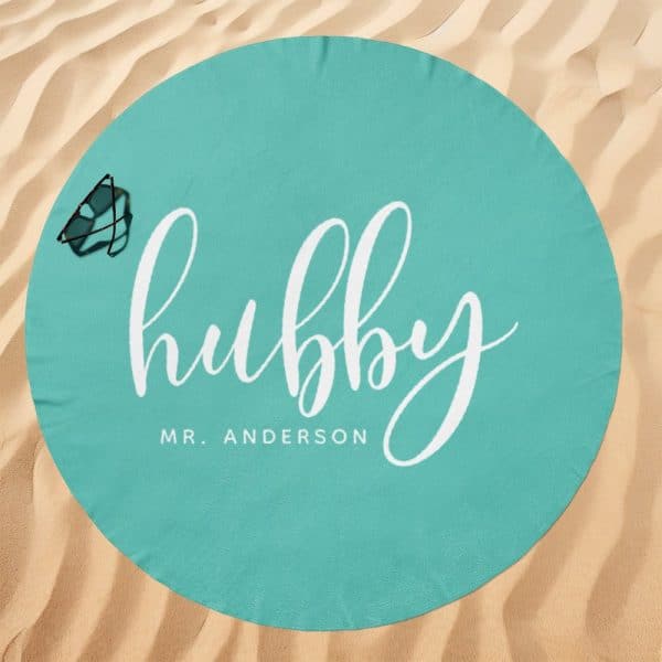 Teal Round Beach Towel With The Word Hubby In White Cursive Lettering And Mr. Anderson Below.