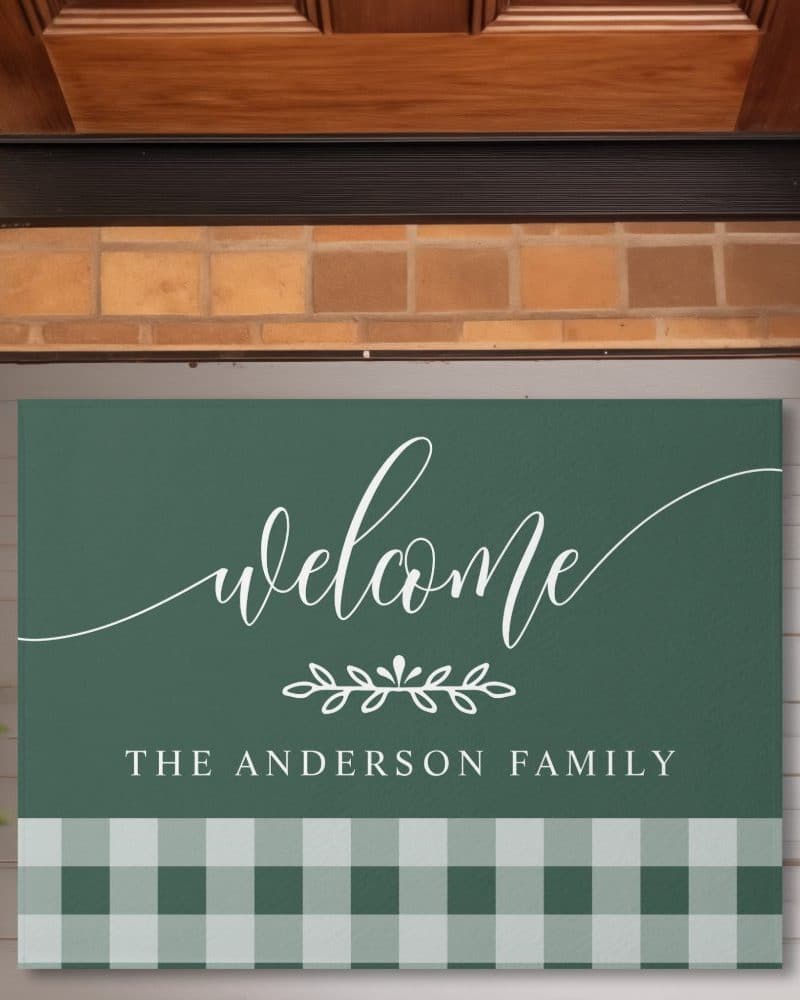 Green welcome mat with the Anderson family name and a green and white checkered bottom border.