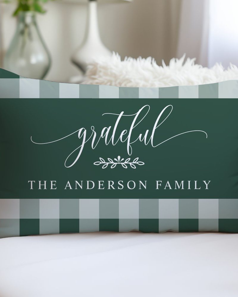 Green and white gingham rectangular pillow with the word grateful in a script font and the text The Anderson Family below.