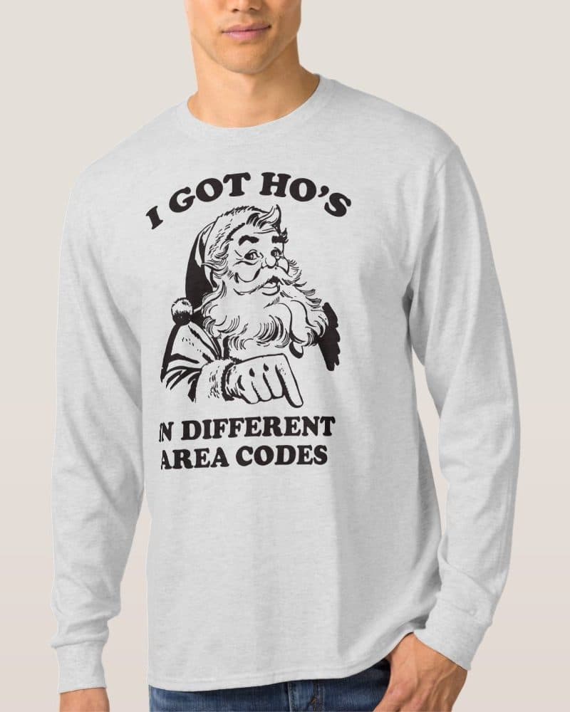 Light gray long-sleeved shirt featuring a black and white illustration of Santa Claus pointing down, with text above and below him that reads, I got HO's in different area codes.