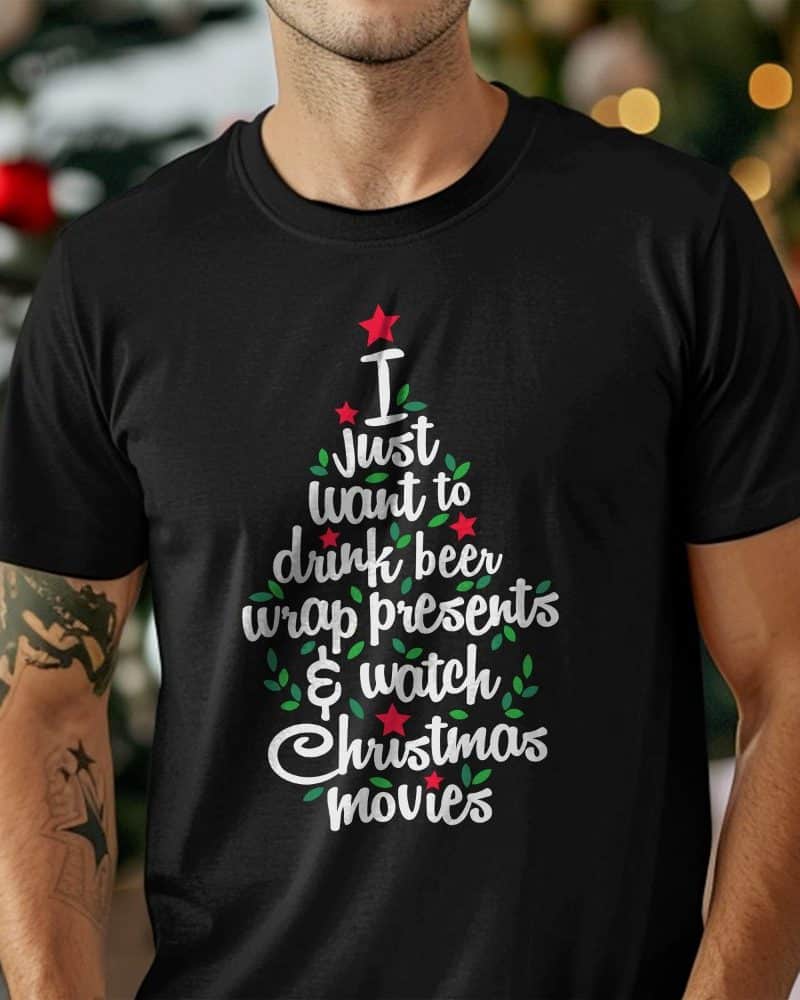 Person wearing a black t-shirt with a Christmas tree design that says I just want to drink beer, wrap presents & watch Christmas movies.