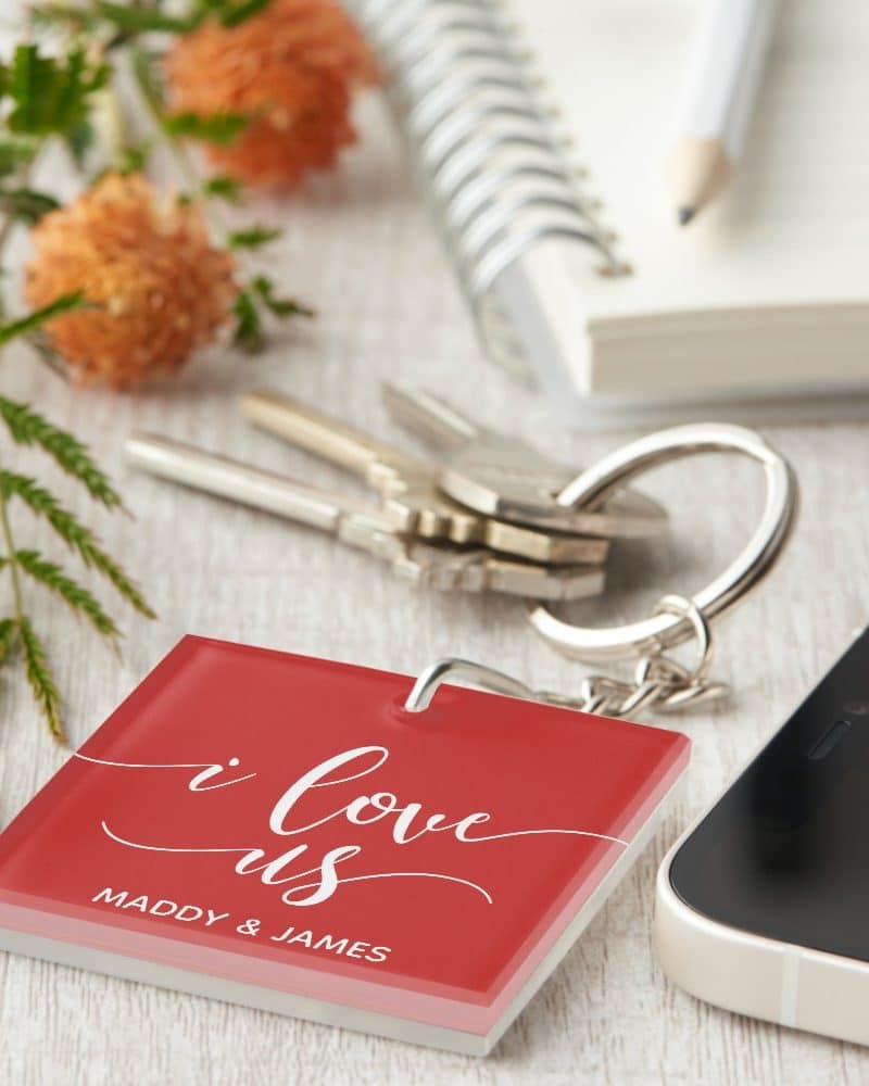 Red square keychain with I love us and a couple's names.