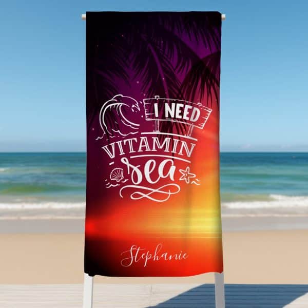Beach Towel With A Sunset Design, Palm Trees, Ocean Wave, And The Text I Need Vitamin Sea, Personalized With The Name Stephanie.