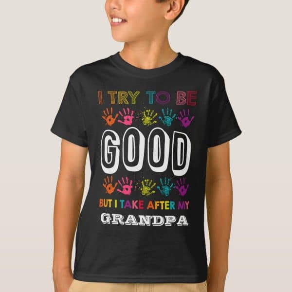 Child Wearing A Black T-Shirt That Says, I Try To Be Good, But I Take After My Grandpa. Colorful Handprints Surround The Text.