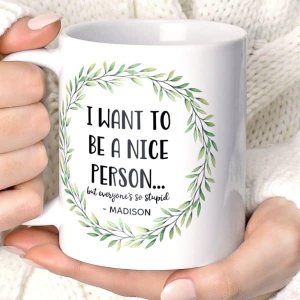 White Coffee Mug With A Green Leaf Wreath And Sarcastic Text: I Want To Be A Nice Person But Everyone'S So Stupid. Madison.